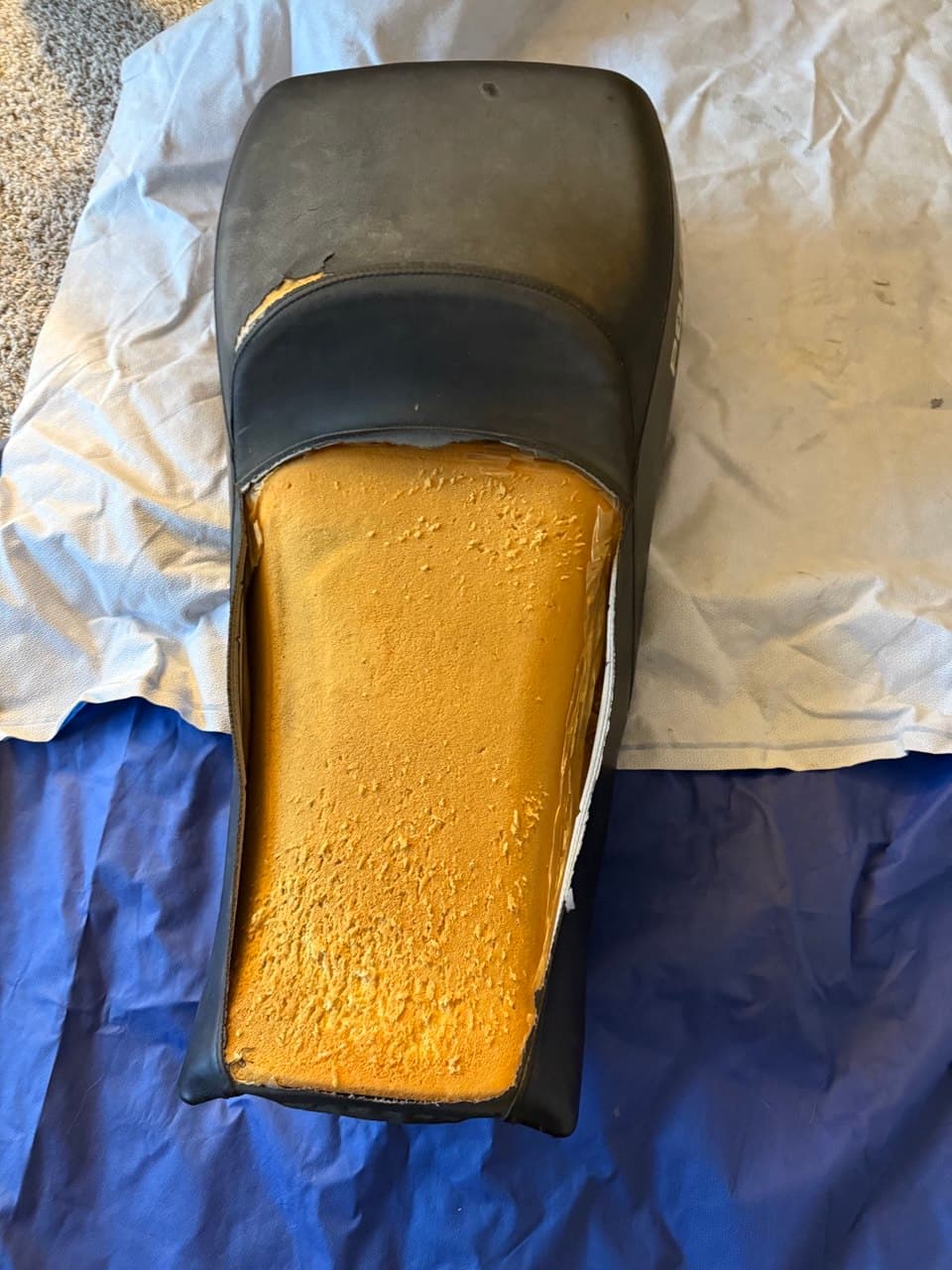 Polaris seat before restoration with torn vinyl and exposed foam